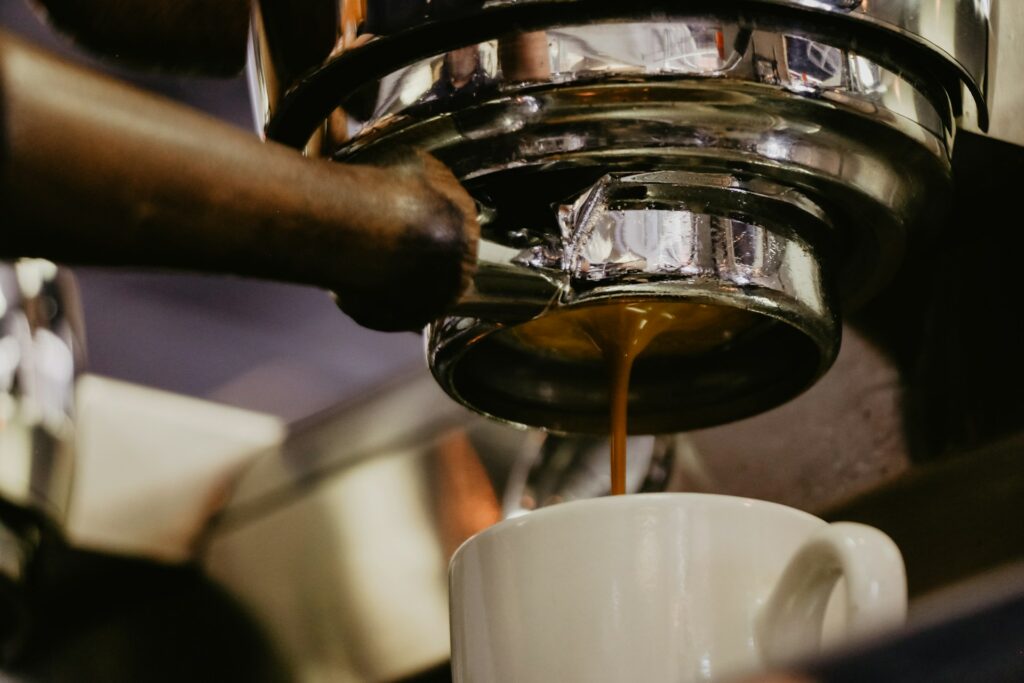 Espresso extraction flowing from portafilter spouts during a timed shot